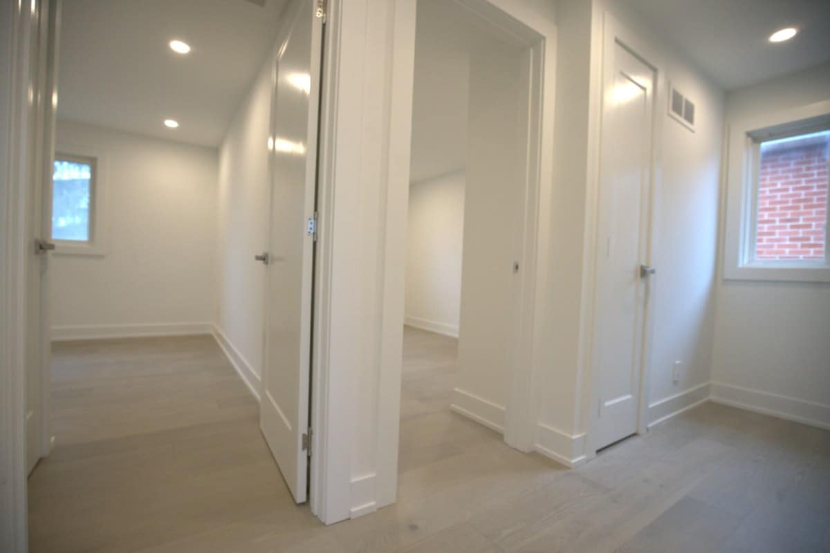 Basement suite hallway leading to bedrooms with windows, where fire separation, alarms and bedroom egress are checked for a legal basement apartment