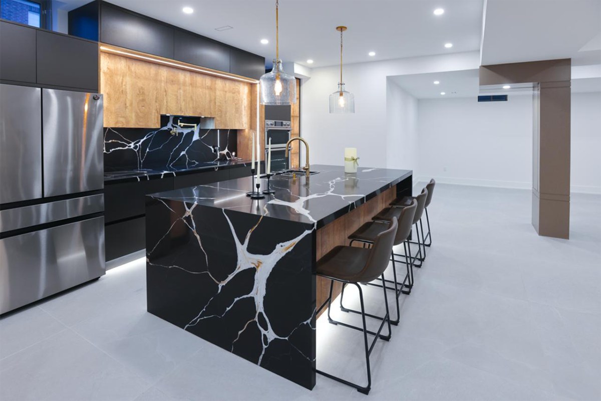 Finished basement kitchen with a marble island and pot lights, the stage a legal basement reaches once every City inspection is signed off