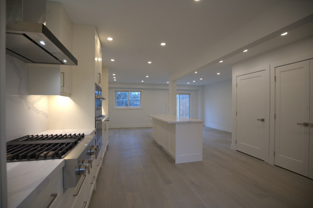 Lower-level kitchen with range hood and island in a finished basement, the type of self-contained space the Mississauga additional residential unit rules cover